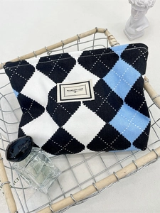 Checkered pattern cosmetic bag with zipper and Pleasant Time label in a stylish basket