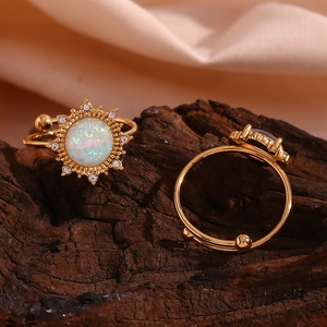 Detailed macro view of 18K gold plated opal sunflower rings on a dark wooden surface