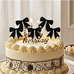 Macro detail of five black polyester ribbon bow toppers for birthday cake decoration