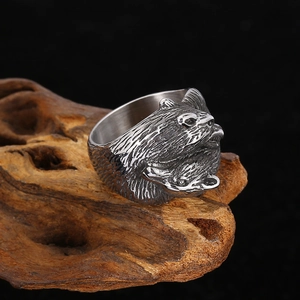 Detailed close-up of a silver wolf head relief carving on a rugged men's titanium steel ring