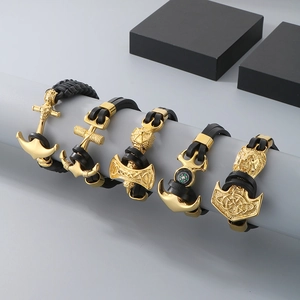 Detail view of men's anchor, axe, and compass bracelets in gold and black leather