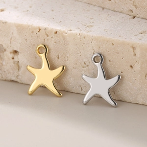 Close-up of gold and silver starfish pendants on stone for DIY jewelry making