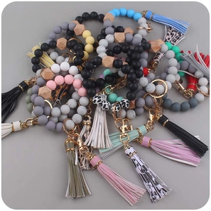 Detailed view of silicone beaded wristlet keychains with leather tassels and leopard prints