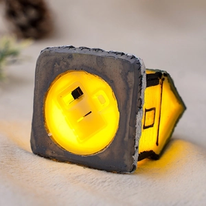 Detailed close-up of the bottom power switch on a luminous resin Christmas house