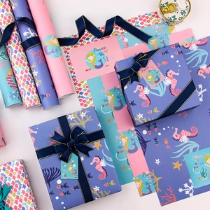 Papier cadeau sirène sur le thème marin avec rubans et boîtes en violet et bleu