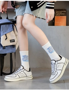 Close-up of white mid-top sneakers with Young Captain socks in a lifestyle setting