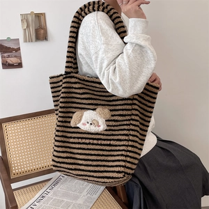 Detailed texture of fuzzy striped tote bag featuring a cute cartoon dog embroidery