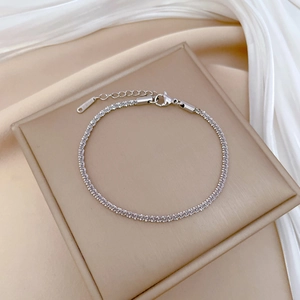Detailed macro view of silver chain bracelet with lobster clasp and S.STEEL engraved tag
