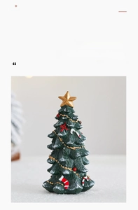 Detailed view of mini resin Christmas tree with faux snow, candy canes and gold star