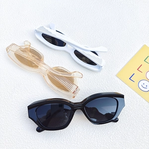 Three pairs of vintage cat eye sunglasses in black, white, and amber on a white surface