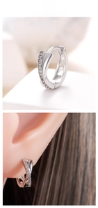Detail of silver crossover hoop earrings with pavé cubic zirconia on silicone ear model