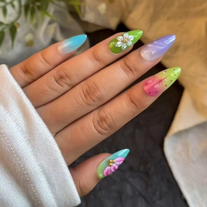 Detail of almond-shaped gradient press-on nails with 3D flowers and pearl accents