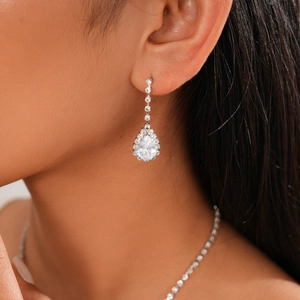 Detail of silver drop earrings with zircons and matching necklace on a model