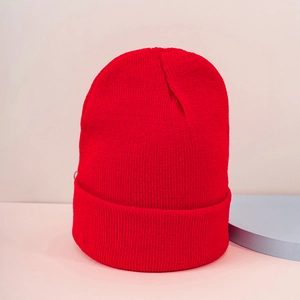 Detailed texture of red ribbed knit beanie with wide folded cuff on modern background