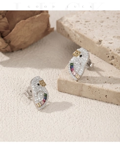 Macro detail of S925 silver parrot stud earrings with colorful zirconia stones