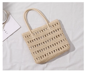 Close-up of beige hollow woven straw tote bag with intricate handmade rope texture details