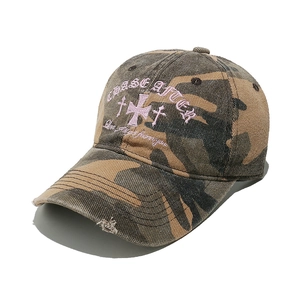 Detail of vintage camouflage baseball cap with pink cross embroidery and distressed brim