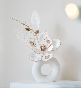 Minimalist white orchid with gold glitter details in a white matte ceramic base