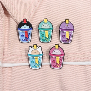 Set of five Adventure Time character-themed enamel milk tea pins on pink denim fabric