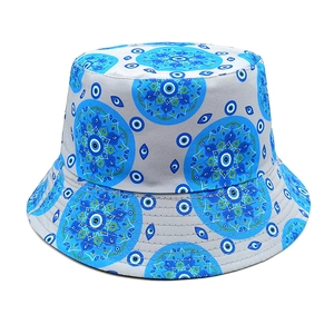 Close-up of fabric texture and blue evil eye pattern on a light gray bucket sun hat