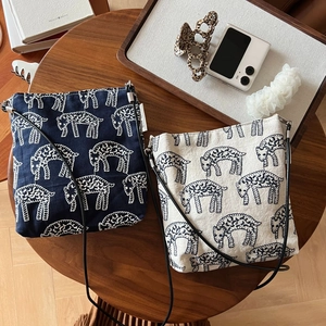 Flat lay of navy and beige cotton linen crossbody bags with cute sheep embroidery