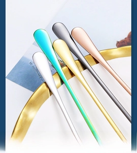 Macro shot of colorful long-handle stainless steel spoons with matte metallic texture