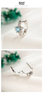 Macro detail of star-shaped 316L steel hoop earring with light blue zircon and clicker hinge