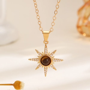 Macro shot of gold sunburst pendant with tiger eye stone and white zircon stones