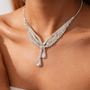 Detailed view of layered silver necklace with sparkling water-drop diamond pendants on a model