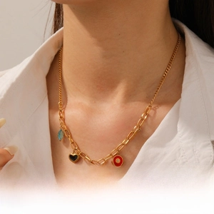 Détail du collier à chaîne dorée avec pendentifs colorés en forme de cœur et papillon