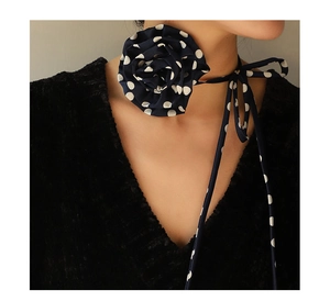 Detail of navy blue polka dot rose choker with long chiffon ribbon on model