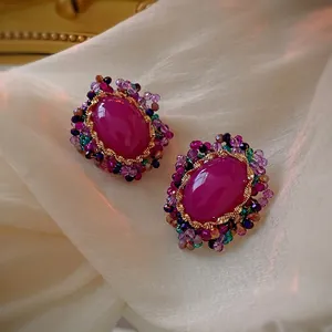 Vintage oval purple crystal earrings with colorful beads on white silk background