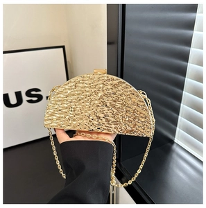 Close-up of golden semi-circular evening bag with metallic hammered texture and chain