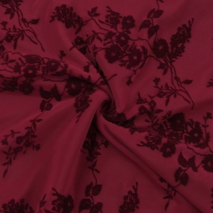 Close-up of deep red floral velvet flocking on sheer mesh fabric with elegant drape