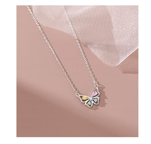 Macro shot of silver butterfly necklace with colorful teardrop gemstones and crystals