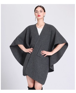 Detail of grey wool blend knit poncho cape featuring functional front pockets