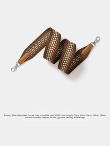 Close-up of 5cm wide checkered woven shoulder strap with leather ends and silver metal hooks