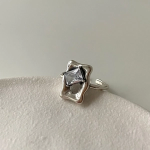 Detailed view of irregular 925 silver ring with square zircon on textured base