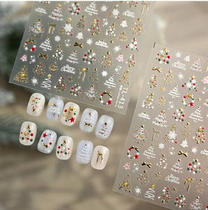 Detailed 3D gold embossed Christmas nail stickers with tree, bell, and snowflake designs