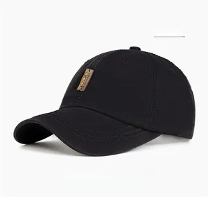 Close-up of black washed cotton baseball cap with vintage leather label and stitched brim