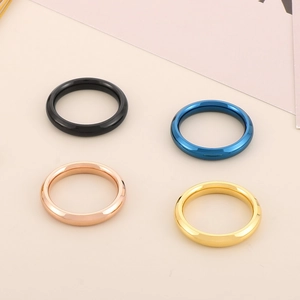 Anelli in acciaio al titanio da 4mm in nero, blu, oro e oro rosa su base beige neutra