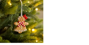 Vue détaillée d'un pendentif bonhomme de pain d'épices avec nœud rouge sur sapin de Noël