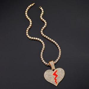 Détail du collier hip hop doré avec pendentif cœur brisé givré et chaîne tennis