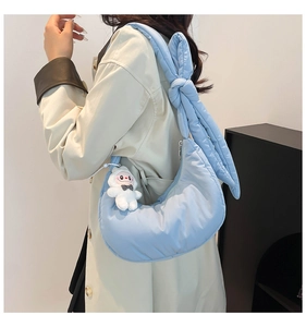 Détail du sac croissant matelassé bleu clair avec tissu doux et grande bandoulière nouée