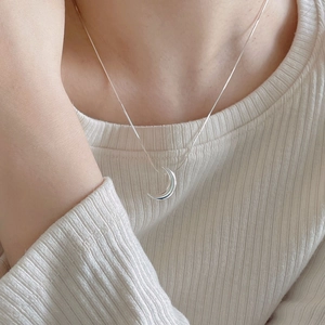 Minimalist 925 sterling silver crescent moon pendant necklace worn on a female model
