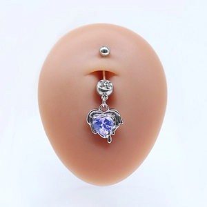 Detailed view of silver navel ring featuring a purple heart gem with wings on model