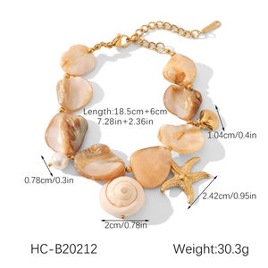 Detail view of gold-plated stainless steel shell bracelet with starfish and pearl charms