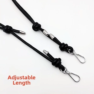 Detail of adjustable black leather shoulder strap with silver metal hooks for handbags