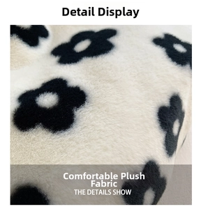 Close-up of soft plush fabric detail featuring vintage black floral patterns on beige surface
