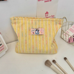 Détail de la trousse de maquillage en tricot jaune avec écusson dalmatien et fermeture